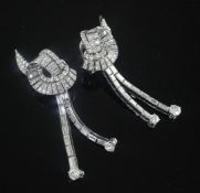 A nice pair of platinum and diamond encrusted scrolling and double drop earrings, set with round and