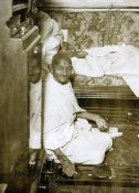 Gandhi, Mohandes Karamchand. An original press photograph of Gandhi seated spinning with a Charka,