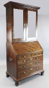 A George III mahogany bureau bookcase, with mirrored doors over a fall enclosing a well-fitted