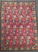 A large Kelim carpet, with polychrome floral field on a puce ground, 11ft 2in by 8ft 1in.