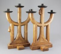 A pair of Robert 'Mouseman' Thompson oak candelabra, of gothic design with wrought iron sconces,