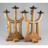 A pair of Robert 'Mouseman' Thompson oak candelabra, of gothic design with wrought iron sconces,