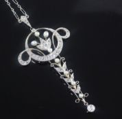 A Belle Epoque gold and platinum, diamond and seed pearl pendant, of scrolling form with tapering