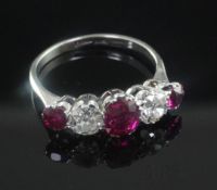A 1940's platinum and graduated five stone ruby and diamond half hoop ring, size Q.
