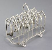 A Victorian gothic style seven bar toastrack by Thomas Smily, on four scroll feet, London, 1872, 6.