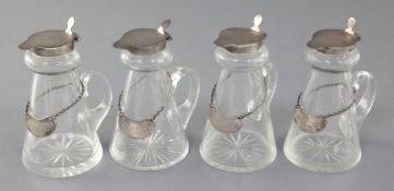 A set of four 1930's silver topped glass whisky tot jugs by Goldsmiths & Silversmiths Co Ltd,