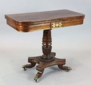 A Regency brass inset rosewood card table, with D shaped top on fluted stem and downswept legs,