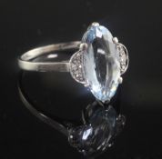 A mid 20th century platinum, aquamarine and diamond set dress ring, with marquise shaped aquamarine,