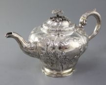 A Victorian silver teapot, of inverted pear shape and embossed with figures and dogs in hunting