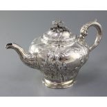 A Victorian silver teapot, of inverted pear shape and embossed with figures and dogs in hunting