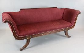 A pair of Regency style mahogany boat shaped settees, with parcel gilt moulded frames and burgundy
