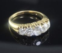 An early 20th century gold and graduated five stone diamond ring, set with old cushion cut stones,