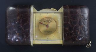 A gilt and leather outer cased Movado Ermetophon travelling watch, with baton numerals.