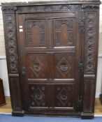 An antique carved oak press cupboard, incorporating sections of 17th century carvings, W.134cm H.