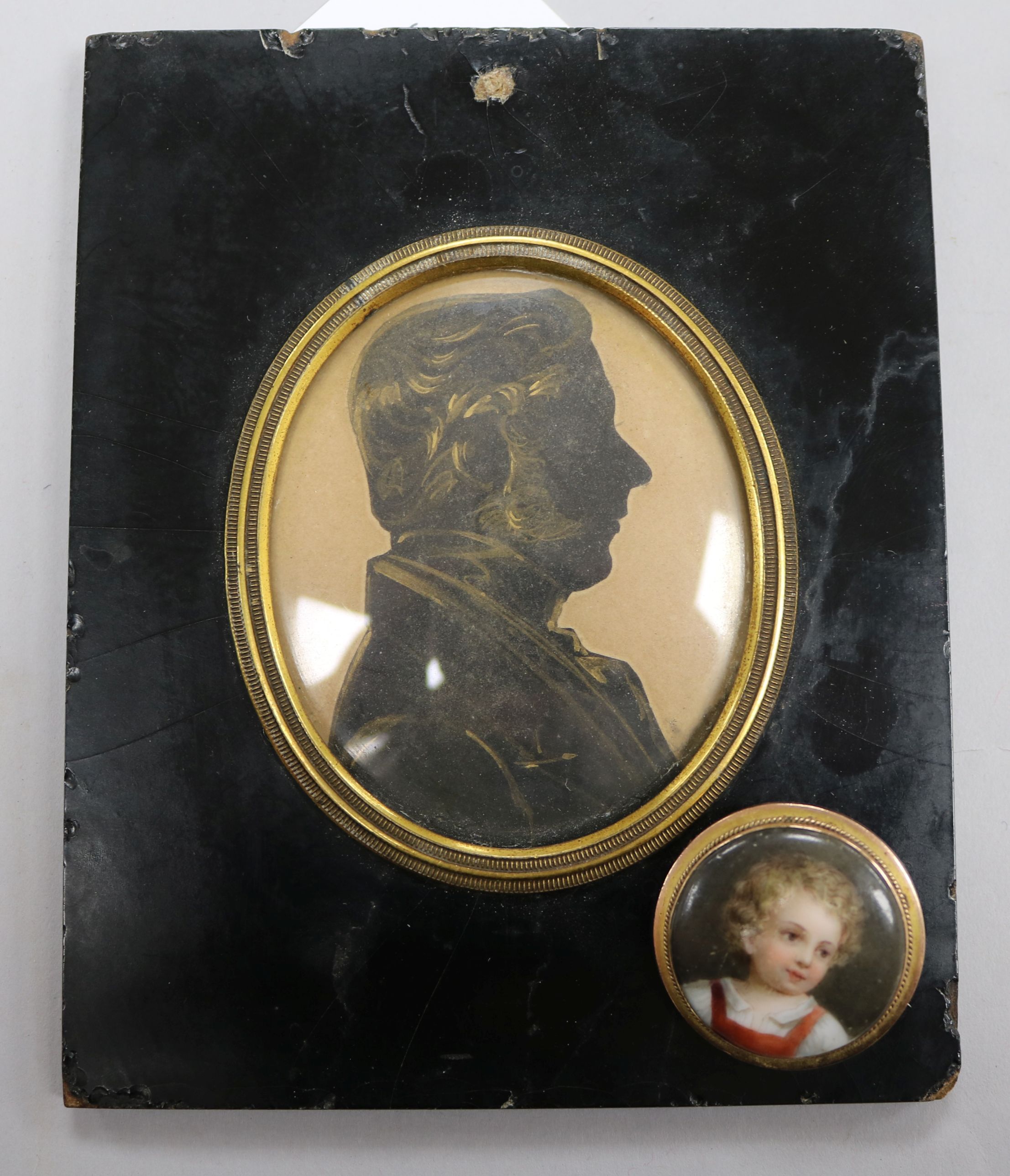 A gold mounted portrait miniature brooch and a silhouette of a gentleman