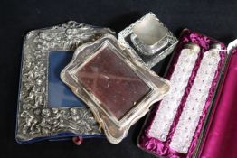 Two silver topped cut glass toilet jars, on by Sampson Mordan, two photograph frames and a silver