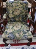 An Edwardian Georgian style mahogany Gainsborough chair, with foliate carved frame, on claw and ball