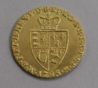 A George III gold spade Guinea 1795, plugged hole and over-gilded otherwise EF