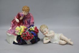 A German bisque piano baby and a Royal Doulton group of flower sellers children