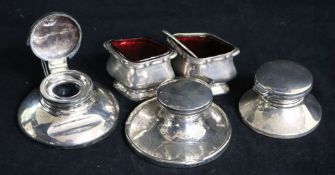 Three silver inkwells and a pair of silver salts.