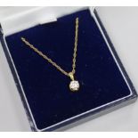 A modern 18ct gold and solitaire diamond pendant, on a 9ct gold chain.