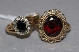 A sapphire and diamond oval cluster ring, 9ct gold setting and a 9ct gold garnet-set dress ring.