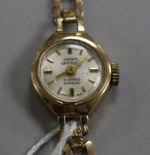A lady's 9ct gold Swiss Empire manual wind wrist watch on a 9ct gold bracelet.