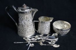 An Indian white metal three piece tea set and assorted spoons etc.