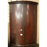 A George III inlaid oak bowfronted hanging corner cupboard, W.72cm