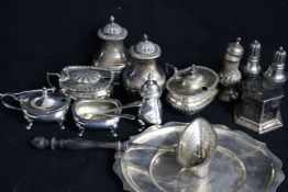 Eleven assorted silver condiments, a silver strainer and a silver stand.