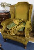 A Georgian style wing back armchair with gold upholstery