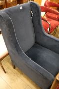 A dark blue dralon upholstered wing armchair