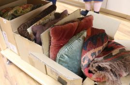 A collection of wool worked cushions, rug and textiles