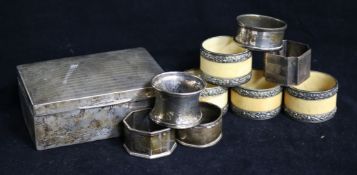 A silver cigarette box and nine assorted napkin rings including five silver.