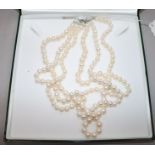 A triple strand cultured pearl necklace with silver clasp.