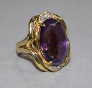 An 18ct gold, amethyst and diamond set oval dress ring, size K.