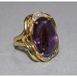 An 18ct gold, amethyst and diamond set oval dress ring, size K.