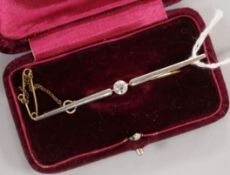 A 15ct gold bar brooch set with a central diamond, in fitted case