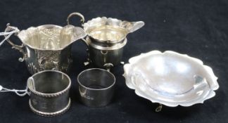 Two silver cream jugs, a small silver shaped dish and two napkin rings