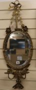 An oval mirror with ribbon crest H.85cm