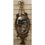 An oval mirror with ribbon crest H.85cm