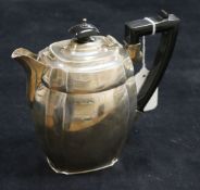 A silver teapot, of oval canted form with ebonised handle and finial, Chester 1936, S
