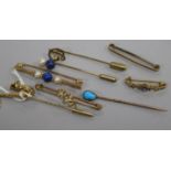 A 9ct gold saxophone stick pin, a similar initial pin and tiepin and five various unmarked items,