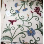 A crewel work double bedspread, embroidered with trailing flowers and foliage and a piece of