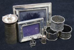Three silver napkin, a silver pepper mill, two photo frames, a miniature pepperette and a