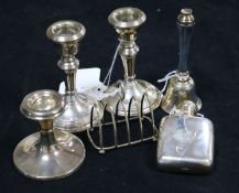 A small silver hip flask, a pair of silver dwarf candlesticks, another candlestick, a small toast
