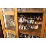 An oak cabinet containing miniature shoes