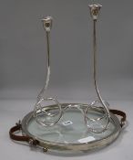 A silver candelabra and a silver glass chrome and leather strapped tray