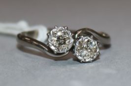 An 18ct and platinum, two stone diamond crossover ring, size O.