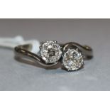 An 18ct and platinum, two stone diamond crossover ring, size O.